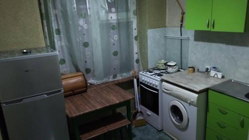 a small kitchen with a stove and a washing machine at Kandelaki in Tbilisi City