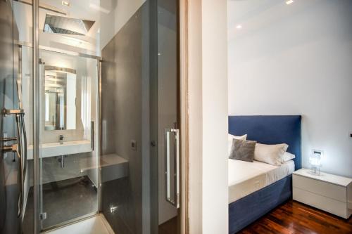 a bathroom with a glass shower and a bed at Pgrhome Luxury Apartments Riverside in Rome