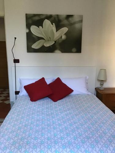 1 dormitorio con 1 cama con 2 almohadas rojas en Nel Giardino di Ester B&B, en Barile
