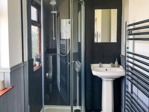 ein Bad mit einer Glasdusche und einem Waschbecken in der Unterkunft Mains Of Auchmedden Cottage in Pennan