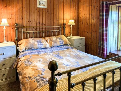 Mains Of Auchmedden Cottage في Pennan: غرفة نوم بسرير وجدران خشبية وارضيات خشبية