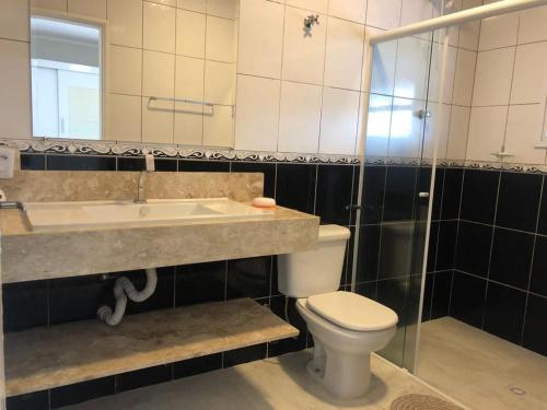 a bathroom with a sink and a toilet and a mirror at Casa de Campo Pardinho Eco Ninho Verde 2 in Pardinho