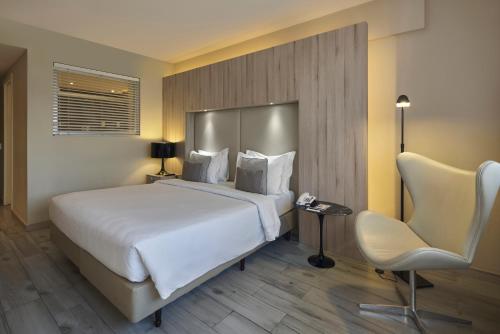 a hotel room with a bed and a chair at Radisson Blu Belo Horizonte Savassi in Belo Horizonte