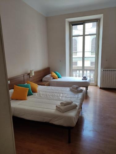 two beds in a room with a large window at Hotel Big Bang in Rome