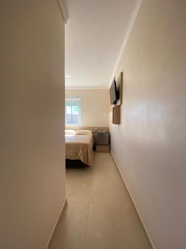 a bedroom with a bed and a television on a wall at Pousada São Gabriel in Ametista do Sul