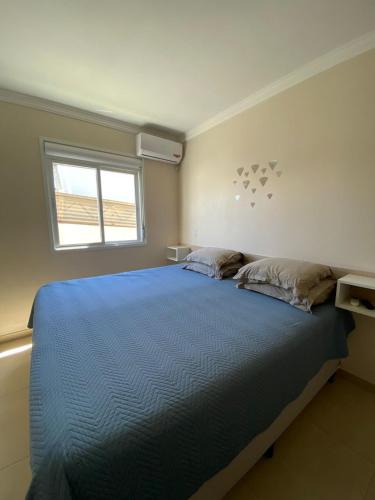 a bedroom with a blue bed with a window at Pousada São Gabriel in Ametista do Sul