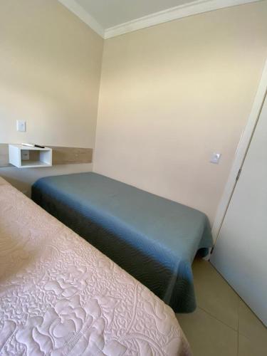 a bedroom with a bed with a blue blanket at Pousada São Gabriel in Ametista do Sul