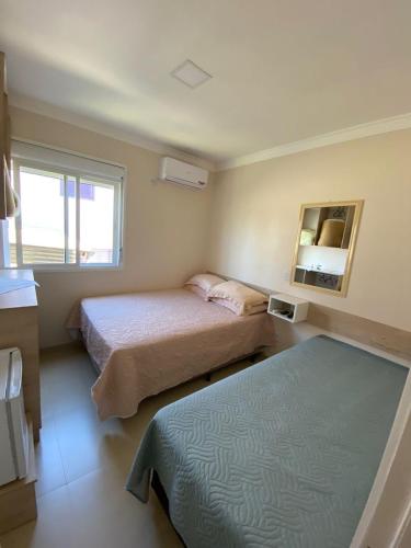 a hotel room with two beds and a mirror at Pousada São Gabriel in Ametista do Sul