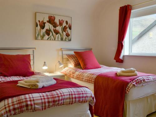 a bedroom with two beds with red and white sheets at Cobble Rigg in Threlkeld