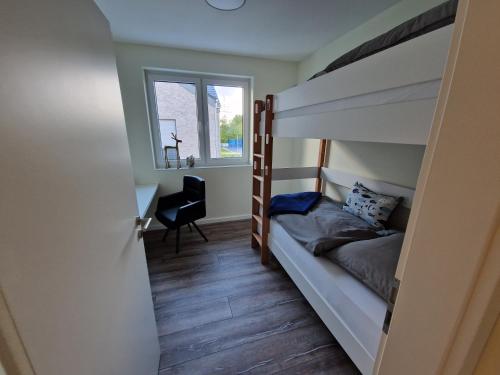 a bedroom with a bunk bed and a desk at Apartment nahe Meyer Werft in Ostfriesland mit Küche & Netflix in Westoverledingen