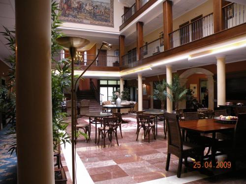 a restaurant with tables and chairs in a building at Hotel Finca La Mansión in Llanes