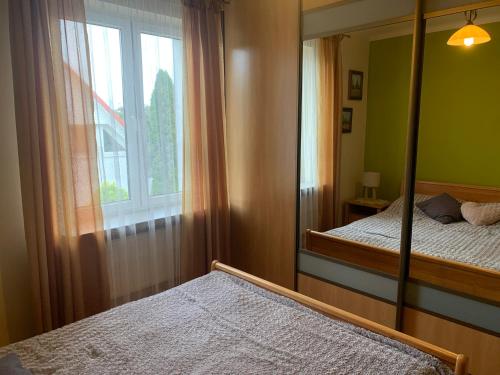 a bedroom with two beds and a mirror at Apartament z ogrodem Harcerska 4 in Zamość