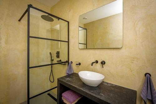 uma casa de banho com um lavatório e um chuveiro com um espelho. em Vakantiewoning "Aruba" te Kralendijk em Kralendijk