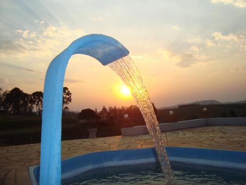 una fontana con tramonto sullo sfondo di Si­tio Vila Davero a Socorro