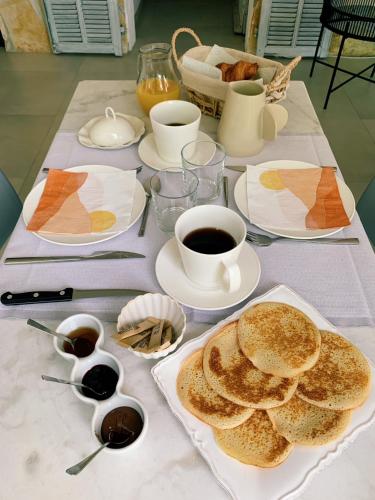 een tafel met pannenkoeken en een kopje koffie bij Mas Saint Antoine - Chambres d'hôtes in Grasse
