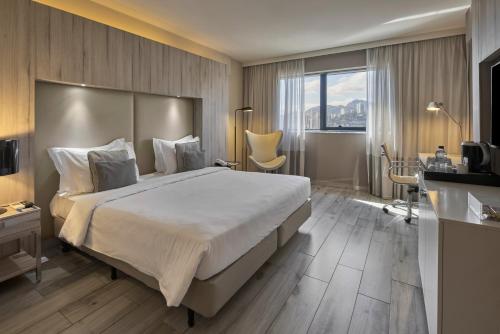 a hotel room with a large bed and a window at Radisson Blu Belo Horizonte Savassi in Belo Horizonte