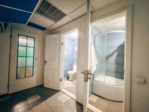 uma casa de banho com uma cabina de duche ao nível do chão e um WC. em Guest House on Saksahanskoho Street em Kiev