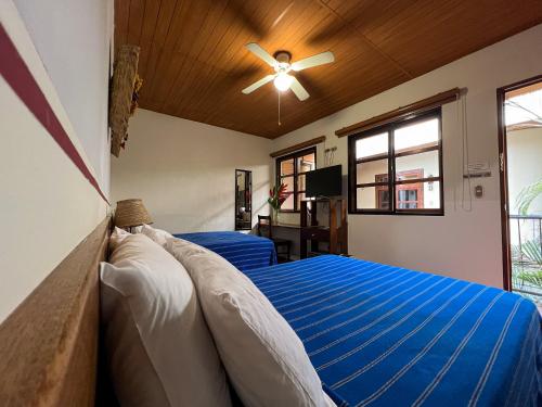 a bedroom with two beds and a ceiling fan at Arbol de Fuego Eco-hotel in San Salvador