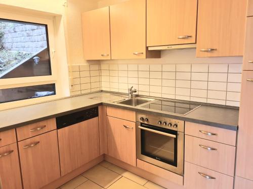 a kitchen with wooden cabinets and a sink at Seestudio mit toller Aussicht am Bodensee in Bodman-Ludwigshafen
