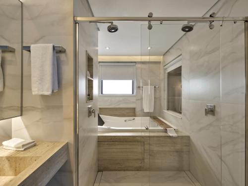 a bathroom with a tub and a sink and a shower at Radisson Blu Belo Horizonte Savassi in Belo Horizonte