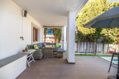 een patio met een bank en een tafel bij VB Guadalmedina 4BDR Renewed Villa in Benalmádena