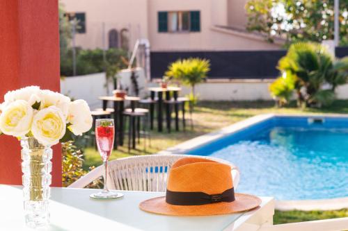 a hat sitting on a table next to a pool at Red House Bed & breakfast in Llucmajor