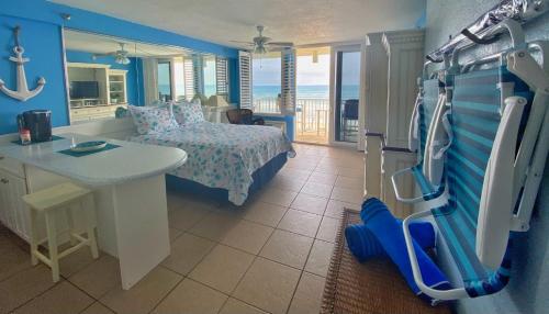 a bedroom with a bed and a sink and a table at Harbour Beach Resort Studios! in Daytona Beach