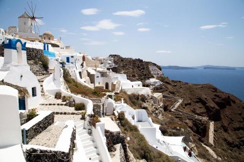 a group of white buildings on a cliff with the ocean at Marizan Caves & Villas in Oia