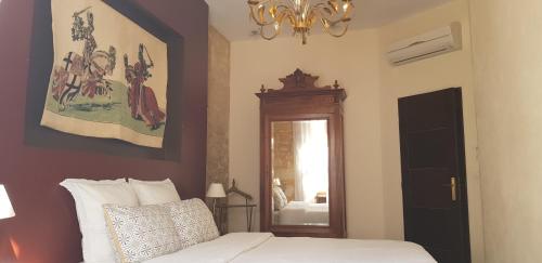 a bedroom with a bed and a mirror and a chandelier at Appartement Le Cardinal in Sarlat-la-Canéda