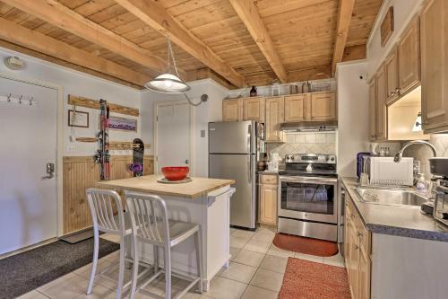 a kitchen with wooden cabinets and a refrigerator at Ski Shuttle and Pool Modern Silverthorne Condo! in Silverthorne