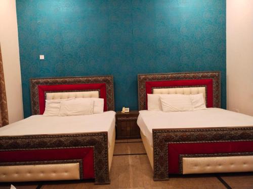 dos camas sentadas una al lado de la otra en una habitación en Hotel Day IN One, en Lahore