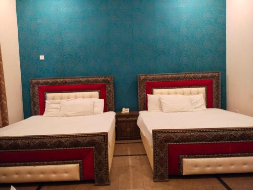two beds sitting next to each other in a room at Hotel Day IN One in Lahore