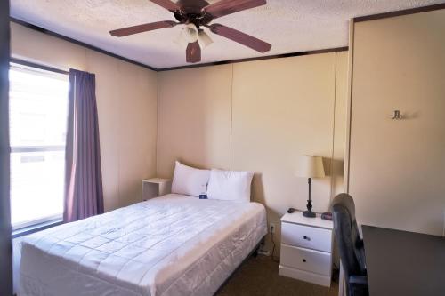 a bedroom with a bed and a ceiling fan at Ellipse Global Lodge in Carlsbad