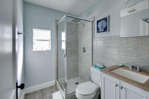 a bathroom with a shower and a toilet and a sink at The Bungalows in St. Pete Beach