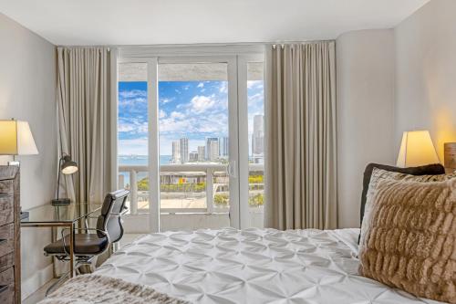 una camera con letto, scrivania e finestra di Ocean Utopia a Miami