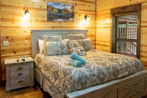 1 dormitorio con 1 cama con pared de madera en Broken Bow Cabin with Hot Tub and Outdoor Fireplace! en Broken Bow