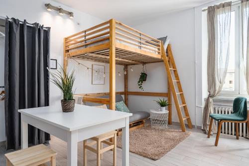 ein Hochbett in einem Zimmer mit einem Tisch und einem Schreibtisch in der Unterkunft Design Suite in the heart of Bicocca University in Mailand