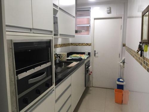a small kitchen with a sink and a stove at Pitangueiras Guarujá próximo da praia in Sao Paulo