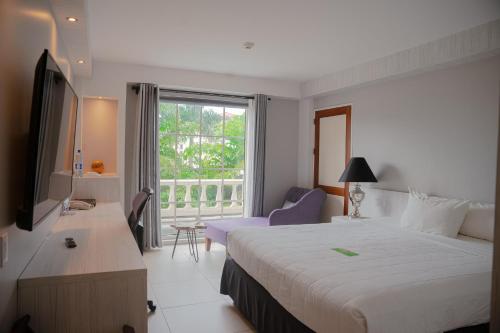 um quarto de hotel com uma cama grande e uma janela em Royal Torarica em Paramaribo