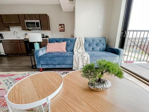 a living room with a blue couch and a table at Sleepover Premier Downtown Des Moines Apartments in Des Moines