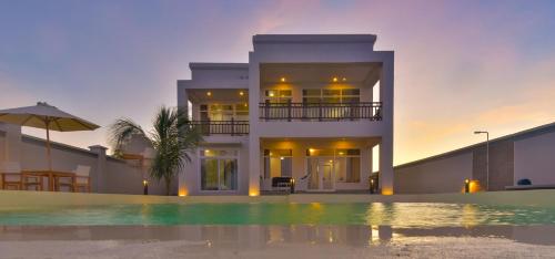 a house with a swimming pool in front of a house at Zanzibar DT Beachfront Villa in Mkunguni