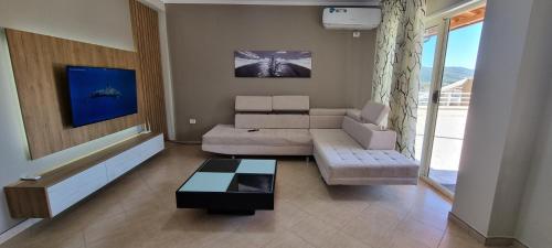 a living room with a couch and a table at Luis Penthouse in Berat