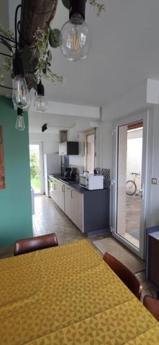 une salle à manger avec une table et une cuisine dans l'établissement cottage proche du bord de mer et au cœur des dunes, à Merlimont