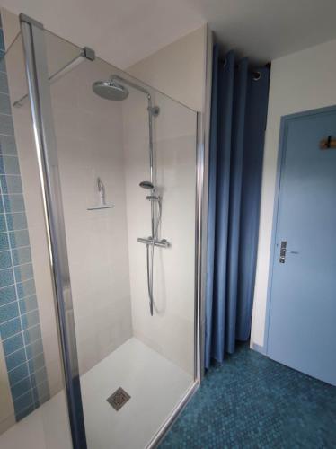 une douche avec une porte vitrée dans une salle de bain dans l'établissement cottage proche du bord de mer et au cœur des dunes, à Merlimont