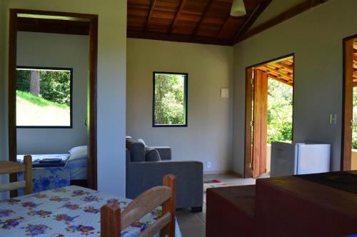 uma sala de estar com um sofá e uma mesa em Chalés Serrinha do Papagaio em Aiuruoca