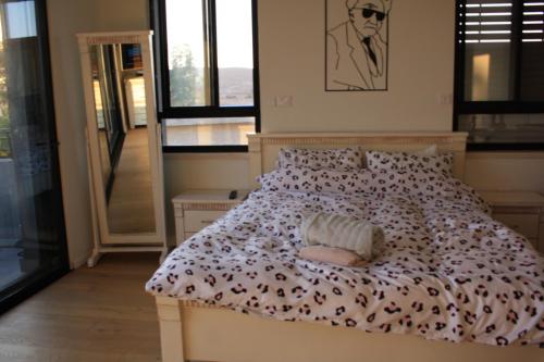 1 dormitorio con cama con edredón en נס הבריאה, en Midreshet Ben Gurion