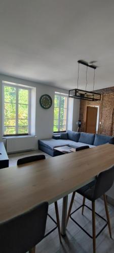un salon avec une table et un canapé dans l'établissement Appartement d'Hippolyte - Vue musée Rimbaud, à Charleville-Mézières
