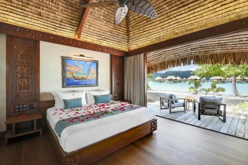 Le Taha'a by Pearl Resorts في Motu Tautau: غرفة نوم مع سرير وإطلالة على المحيط
