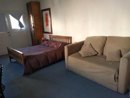 a living room with a couch and a bed at Aquí te Espero in Tandil