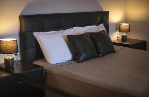a bedroom with a bed with pillows and two lamps at Vretti's apartment in Kýthira